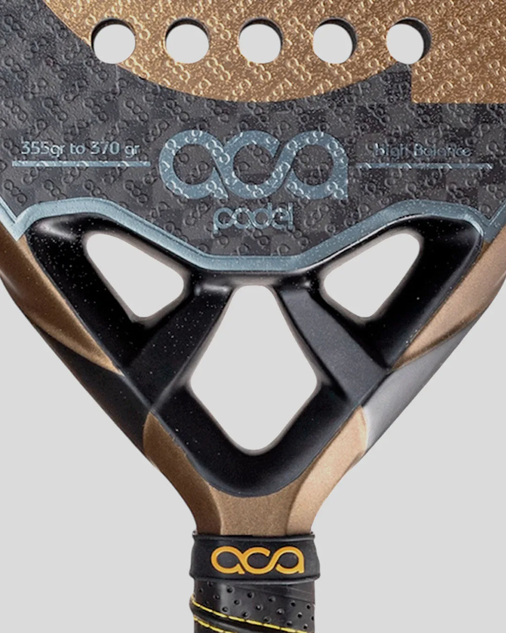 Close-up of a golden padel racket heart branding on a gray background