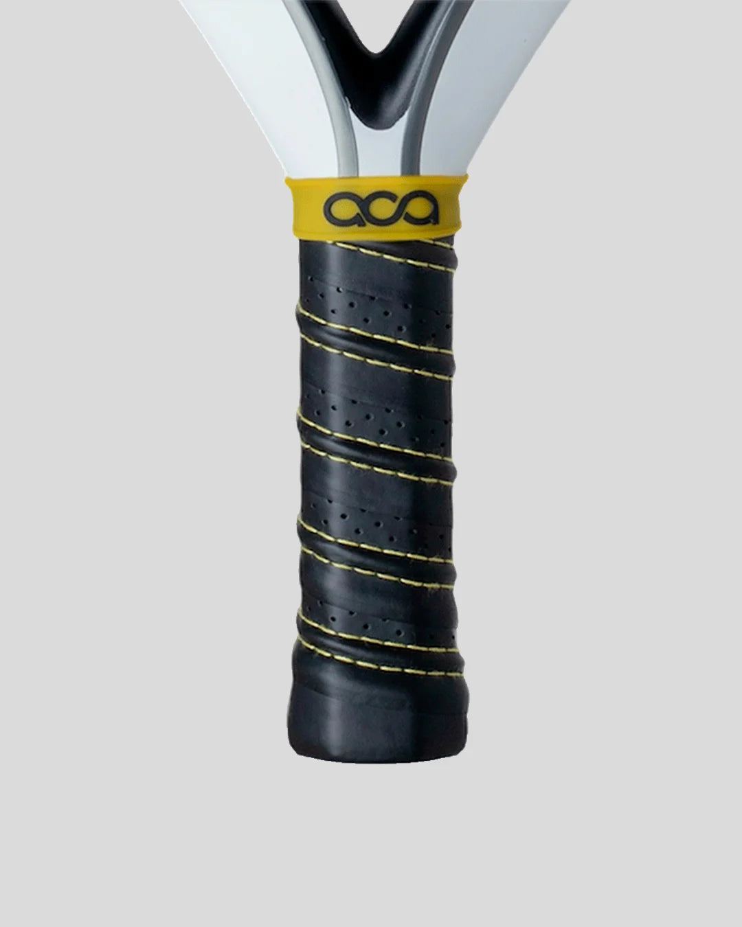 Close-up of a padel racket handle with black grip and yellow ACA branding on a light gray background