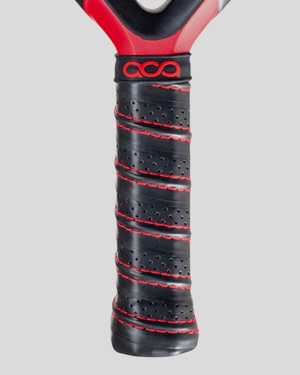 Close-up of a padel racket handle with black and red grip on a gray background